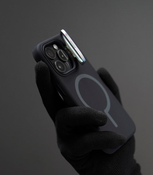 Soft-touch black silicone MagSafe case held by gloved hand, exuding elegance